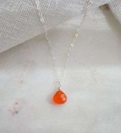 A new variation of our most popular necklace...a Carnelian drop! This necklace is handcrafted with a faceted, genuine, natural Carnelian gemstone. Chains are available in sterling silver or 14k gold fill. Most stones are a bright orange, while some have natural banding, and/or can vary in shades of orange. The stone size averages 7 to 9mm (.27" to 3.5")Carnelian is the orange colored variety of Chalcedony, a quartz. It has been traditionally worn to enhance passion, love, and desire. Carnelian i Droplet Necklace, Popular Necklaces, Necklace Orange, Orange Carnelian, Carnelian Necklace, Carnelian Pendant, Improve Circulation, Energy Stones, Shades Of Orange