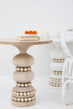 a table that has some balls on it next to a wicker chair and vase