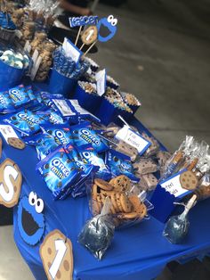 a blue table topped with lots of cookies and candies on top of it's own