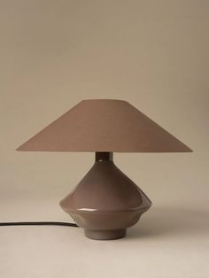 a table lamp with a brown shade on it and a cord attached to the base