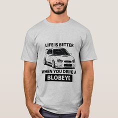 a man wearing a grey t - shirt that says life is better when you drive a blobye