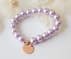 This personalized flower girl bracelet is made with lavender color little glass pearls (8 mm) and rose gold plated initial disc. This stretch pearl bracelet is perfect gift for your flower girls, jr bridesmaids or bridesmaids. Please visit my store to see the other wedding jewelry https://www.etsy.com/shop/asteriasbridal Elegant Personalized Rose Gold Beaded Bracelets, Elegant Personalized Rose Gold Beaded Bracelet, Personalized Rose Gold Charm Bracelet For Wedding, Wedding Pearl Bracelet, Lavender Bracelet, Gold Flower Girl, Junior Bridesmaid Gifts, Flower Girl Jewelry, Flower Girl Bracelets