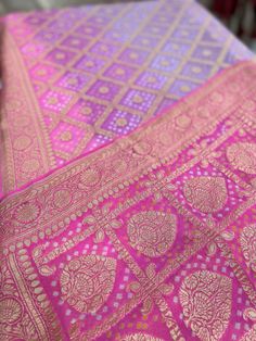 A Handmade Hot Pink & Lavender shaded Pure Khaddi Georgette Bandhani/ Bandhej Saree woven in pure Meenakari Zari- an invitation for a true self-indulgence. The fall and pico are done for this saree. It comes along with a Hot Pink Bandhani Blouse piece that also has a zari border.   Our Policy on Returns, refunds and exchanges: We don't accept requests for returns and exchanges on the below observations: Non-defects: *Small knots or bumps in the silk threads.  *Uneven threads because of korvai pa Purple Bollywood Dupatta For Transitional Season, Purple Wedding Dupatta For Transitional Season, Purple Wedding Dupatta, Purple Bandhani Print Saree, Purple Bandhani Print Saree For Puja, Purple Unstitched Dupatta For Transitional Season, Purple Bandhani Print Traditional Wear For Diwali, Purple Dupatta For Festive Transitional Season, Semi-stitched Lavender Lehenga With Pallu