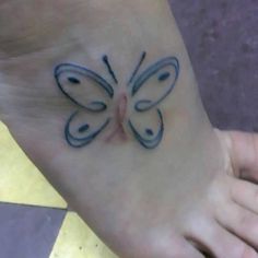 a small butterfly tattoo on the foot