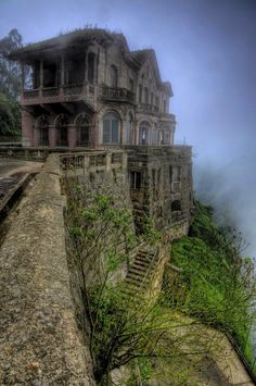 an old house on the edge of a cliff