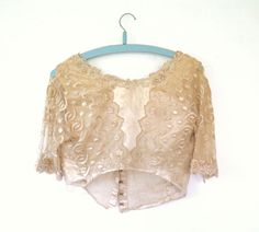 "As found. Simply beautiful original antique Edwardian bodice / top in creamy silk with cream embroidered net lace and beaded neckline. Short lace sleeves with matching beaded details at the edges.  Fastens at the back with hook and loops. In wearable with care condition or display with weakening to the silk and lace in places and a few of the loops for the hook fastenings missing. Please see detailed images and please feel free to message with any queries you may have. Appears handmade and to originally have had a skirt attached. The edge has old stitch marks and has been hand sewn to hem. Available on layaway, Please message us for details. Measurements: - 16\" Shoulders - 9 3/4\" Sleeves - 32\" Bust  - 26\" Waist  - 14.5\" Length  Description: Victorian / Edwardian Bodice in Fair to Goo Beige Blouse, Silk And Lace, Bodice Top, Net Lace, Beaded Neckline, Beige Top, Silk Lace, Cream Beige, Womens Blouses