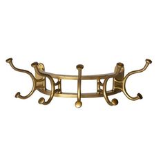 a gold metal shelf with two hooks on the top and one hook at the bottom