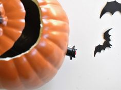 an orange pumpkin with bats on it and some cutouts in the shape of bats