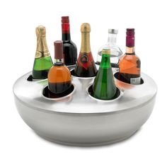 a white bowl filled with lots of different types of wine bottles on top of it