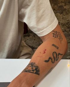 a man with a tattoo on his arm sitting at a table