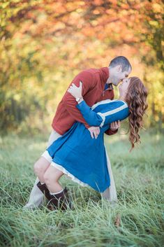 a man and woman are kissing in the grass