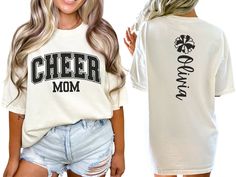 Celebrate your cheerleader with our varsity-style "cheer mom" shirt, featuring bold letters on the front. The back showcases a pom pom and is personalized with your cheerleader's name, making it the perfect gift for any proud cheer mom or mama passionate about cheerleading. COMFORT COLORS 1717 SHIRT: Unisex 100% US cotton - ethically grown and harvested Pre-Shrunk Fabric Relaxed Fit - Size up for a trendy oversized look Seamless Sides Double Needle Stitching Garment-dyed  CARE INSTRUCTIONS: Wash Cheer Shirt Ideas Design, Cheer Fan Shirts, Cheer Family Shirts, Varsity Fan Gear T-shirt With Lettering, Varsity Style Fan Gear T-shirt With Lettering, Varsity Lettering T-shirt For Fan Gear, Cheer Grandma Shirt Ideas, Varsity Crew Neck Tops For Cheerleading, Crew Neck T-shirt With Text Print For Cheerleading