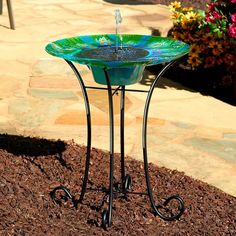 a glass table sitting on top of a pile of dirt next to a flower pot