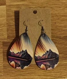 a pair of earrings sitting on top of a wooden table