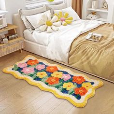 a bed room with a neatly made bed and flowers on the rug