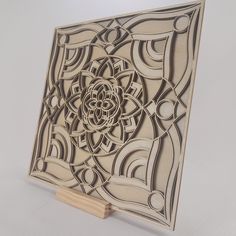 an intricately designed wooden plaque on a stand