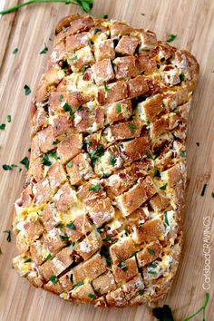 a loaf of bread topped with cheese and herbs