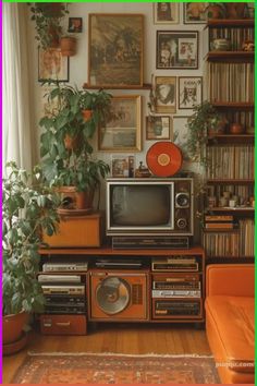 an old fashioned television sitting on top of a wooden entertainment center next to a plant