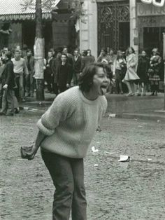 an old black and white photo of a man on a skateboard with people in the background