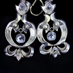 "Georgian silver topped 14k gold drop earrings with over 5 carats of diamonds feature a combination of old mine cut and rose cuts. The stunning earrings have been preserved for nearly 200 years. One has been repaired at some point in its history of ownership. The bottom flourish was reattached and the top of the pendulous was reinforced and reattached. See detailed imagery of repairs. These have not been cleaned by us in case of foil backings on non open backed stone mountings, which were preval Single Cut Diamond Drop Earrings For Evening, Antique Formal Dangle Chandelier Earrings, Antique Dangle Chandelier Earrings For Formal Occasions, Formal Rose Cut Diamond Chandelier Earrings, Formal Chandelier Earrings With Rose Cut Diamonds, Ornate Hallmarked Dangle Chandelier Earrings, Ornate Hallmarked Chandelier Dangle Earrings, Victorian Style Hallmarked Earrings For Formal Occasions, Victorian Chandelier Drop Earrings For Evening