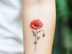 a woman's arm with a red flower tattoo on it