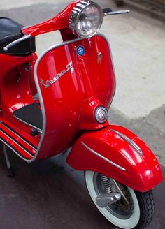 a red scooter is parked on the street