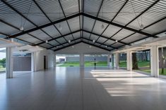 an empty room with lots of windows and white tiles on the floor in front of it