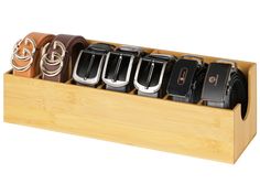 six belts in a wooden holder on a white background