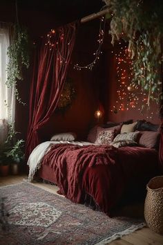 a bed with red sheets and lights hanging from it's headboard in a dark room