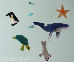 an animal mobile hanging from a ceiling with starfishs and sea animals on it