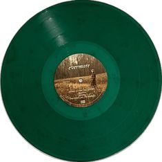 a green vinyl record with an image of a woman standing in the woods on it