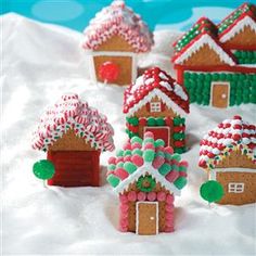 gingerbread houses are decorated with candy canes and sprinkles in the snow