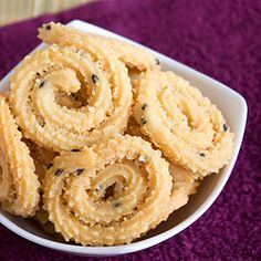 a bowl filled with fried food on top of a purple mat