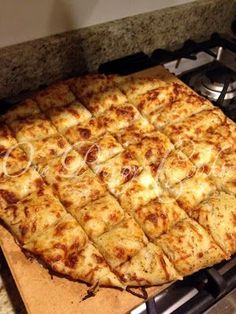 a square shaped pizza sitting on top of a stove