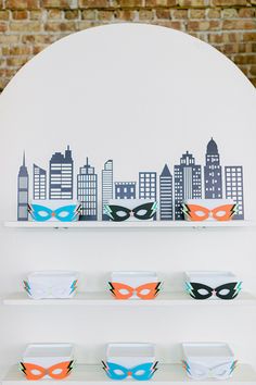 masks on shelves in front of a city skyline wall decal with an arched window