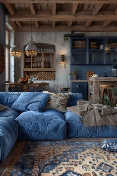 a large blue couch sitting in a living room next to a rug on top of a wooden floor