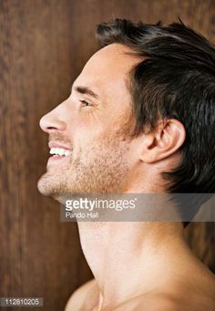 a man with no shirt smiling and looking up