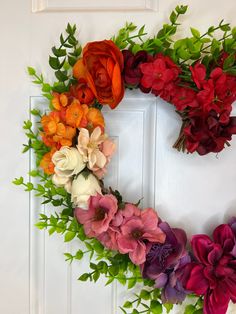 a wreath made out of fake flowers on a door