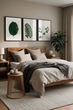 a large bed sitting next to two pictures on the wall in a room with wooden floors