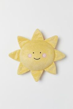 a yellow sun plush toy on a white background