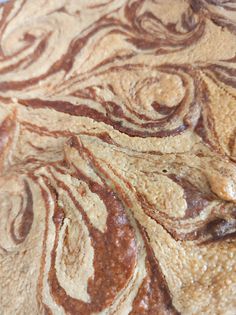 a close up view of some food that is on a plate with brown and white swirls