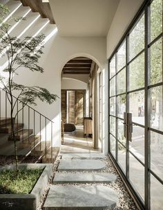 an entry way with stone steps leading up to the front door and trees on either side