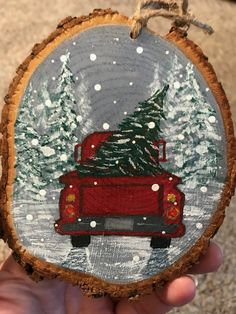 a red truck with a christmas tree on the back is painted on a piece of wood