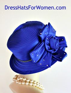 Women's Royal Blue Satin Fashion Designer Haute Couture Hat Headpiece Trimmed With A Large Royal Blue Satin Bow Accented With Crystal Acrylic Rhinestones. This Formal Hat Can Be Worn In Different Positions.

Measurements: Crown Measures 22.5" Standard For Most Women - Condition New - Custom Made

Material: Royal Blue Satin

Dress Hats For Women Specializes In Designer Hats For Women, Hats For Weddings, Cocktail Hats, Haute Couture Hats For Women, High Fashion Hats, Hats For Brides, Kentucky Derb Fitted Royal Blue Hat For Evening, Fitted Royal Blue Hat For Summer, Royal Blue Fitted Hat For Party, Fitted Royal Blue Wide Brim Hat, Fitted Hats For Mother Of The Bride, Spring, Adjustable Blue Hats For Church, Adjustable Blue Hat For Church, Blue Adjustable Hat For Church, Adjustable Royal Blue Hat For Formal Occasions