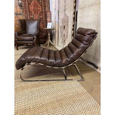 a brown leather chaise lounge chair sitting on top of a rug