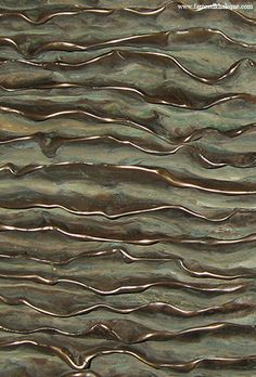 a close up view of an abstract metal surface with wavy lines on the top and bottom