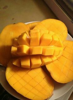 a white plate topped with sliced mangoes on top of a counter