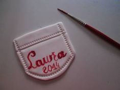 a small embroidered badge with the word laruca 2013 on it next to a paintbrush