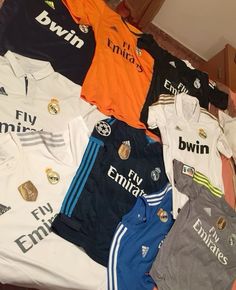 a pile of soccer jerseys sitting on top of a bed