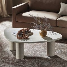 a living room with a couch, coffee table and book on the floor in front of it